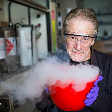 chemist Sidney Perkowitz in front of a smoking red cauldron